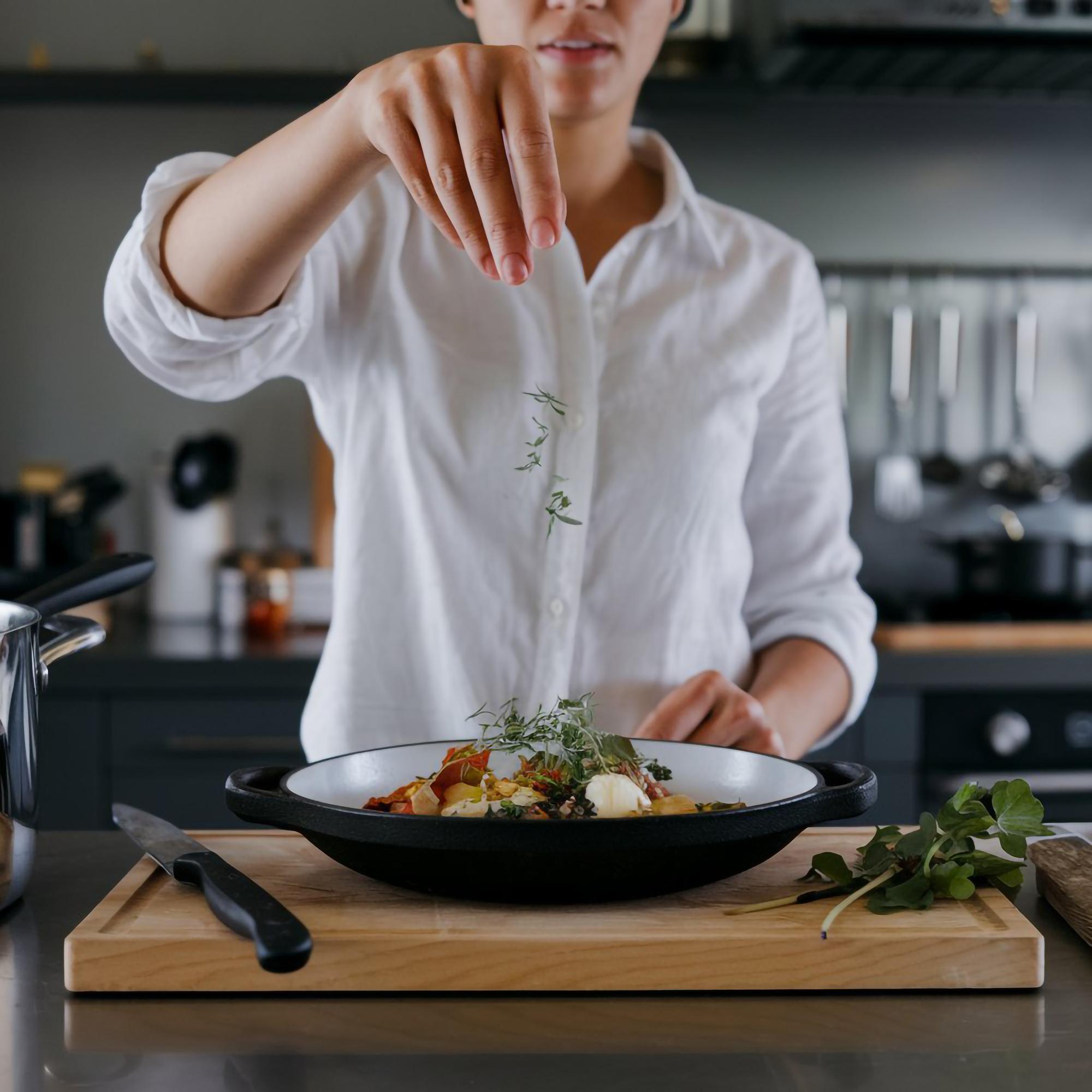 Instructor plating a composed dish in a calm kitchen